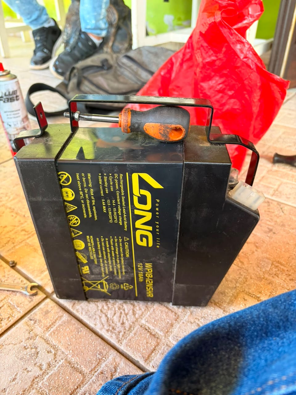 Técnico trocando bateria com chave de fenda