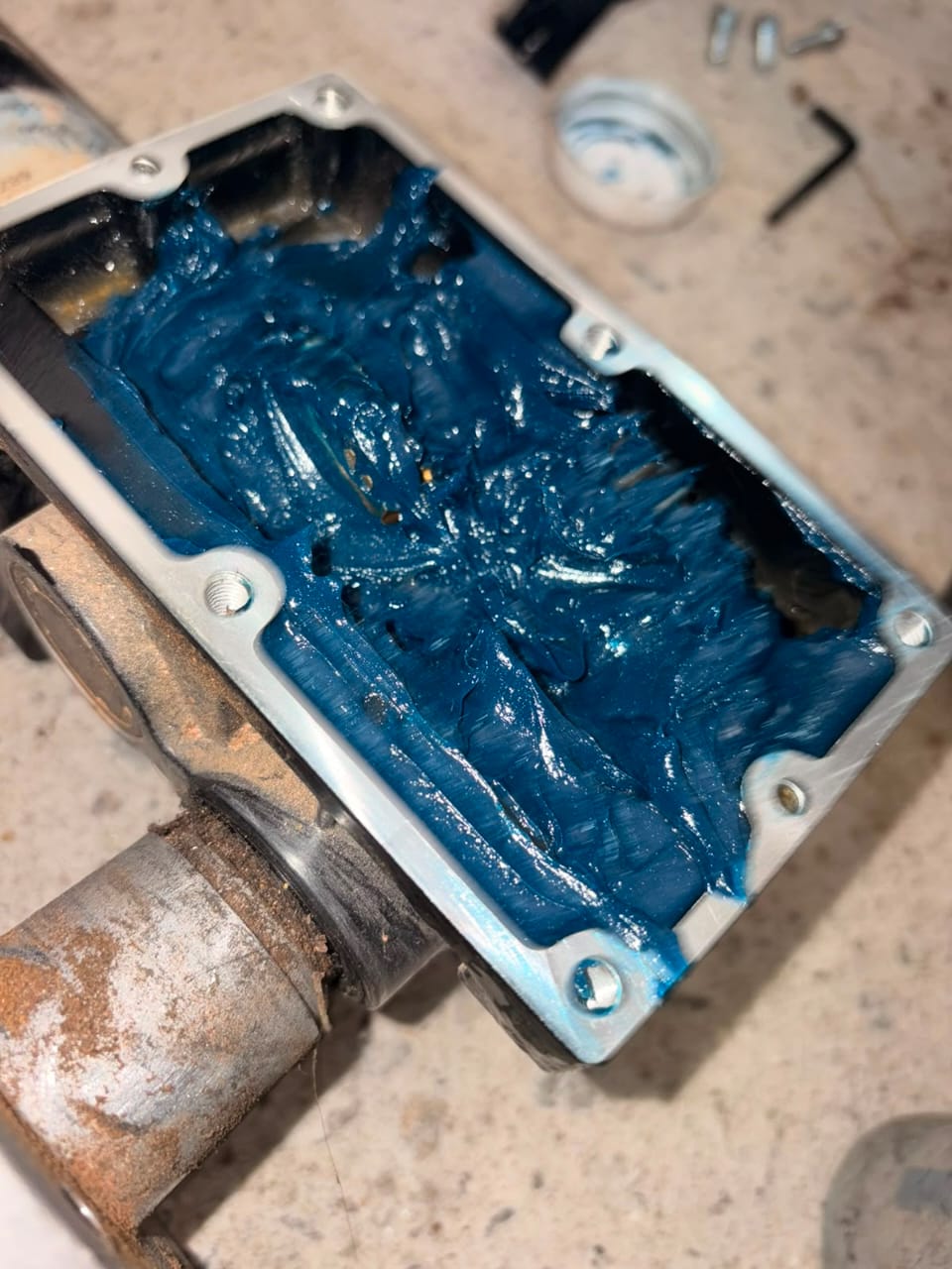 Lubrificação com graxa azul em caixa metálica presa em morsa