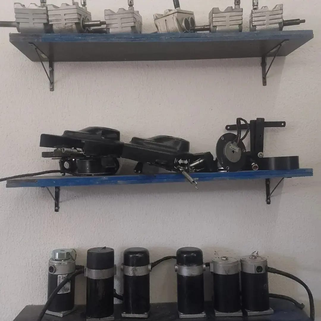 Motores elétricos e componentes organizados em prateleiras da oficina
